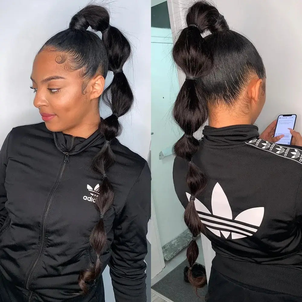 Woman with sleek ponytail hairstyle wearing a black Adidas tracksuit, showcasing stylish hair twists.